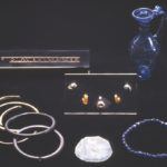 The grave goods of the 'ivory bangle lady' included: (clockwise from top left) a bone openwork mount, beads, earrings and pendant, blue glass jug, blue glass bead bracelet, glass mirror, jet and ivory bracelets. The jug is 123mm tall. c York Museums Trust (Yorkshire Museum).